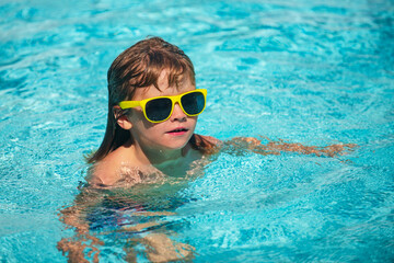 Fototapeta na wymiar Kid having fun in swimming pool. Kid in sunglasses relax on beach.