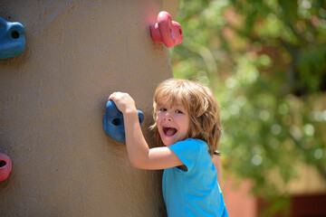 Insurance kids. Portrait of kid boy climbing on practical wall indoor, bouldering training. Health...
