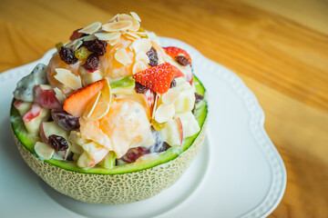 Plate of healthy fresh fruit salad on wooden table. Diet breakfast. Weight loss concept.