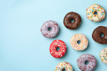 Flat lay with tasty donuts on blue background