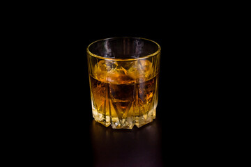 Glass of whiskey isolated on the black background