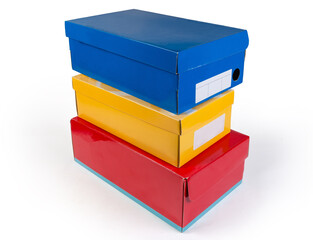 Stacked different cardboard shoe boxes various colors on white background