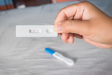 Young woman happy holding after positive pregnancy test.