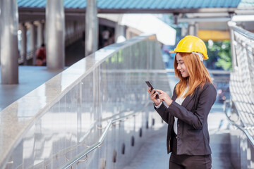 Fototapeta premium Construction engineer in Safety Suit Trust Team Holding White Yellow Safety hard hat Security Equipment on Construction Site. Hardhat Protect Head for Civil Construction Engineer. Engineering Concept