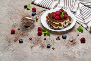 portion of Classic tiramisu dessert with raspberries on grey concrete background