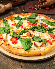 Closeup on pizza napoli with spinach and tomatoes