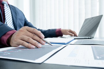 Hand of businessmen are planning business investments related to shares By analyzing and...