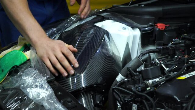 Workers install the carbon part into the car