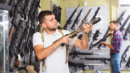 Young man choice pneumatic gun in airsoft market