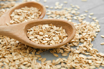 Spoons with raw oatmeal on table, closeup