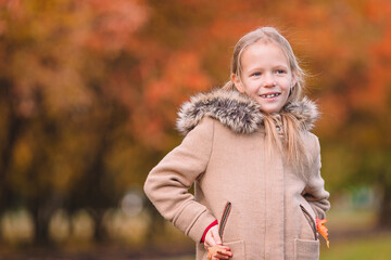 Portrait of adorable little girl outdoors at beautiful autumn day