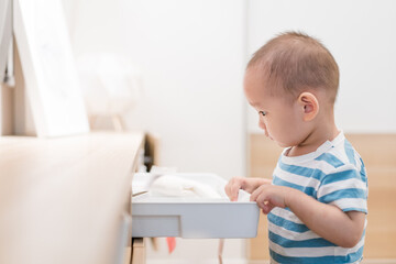Naklejka premium A baby boy of one and a half years old is playing in the room