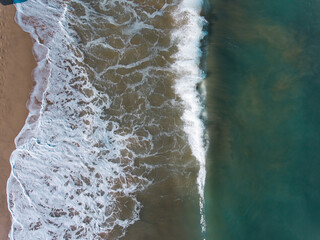 Aerial view of blue sea, waves and beach.