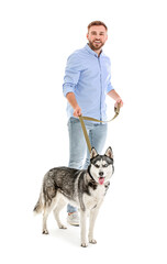 Young man with cute Husky dog on white background