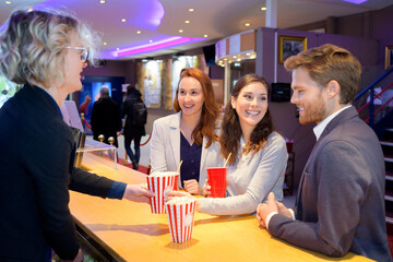young people being served drinks and popcorn at cinema