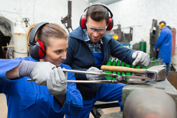 man and woman at metal workshop