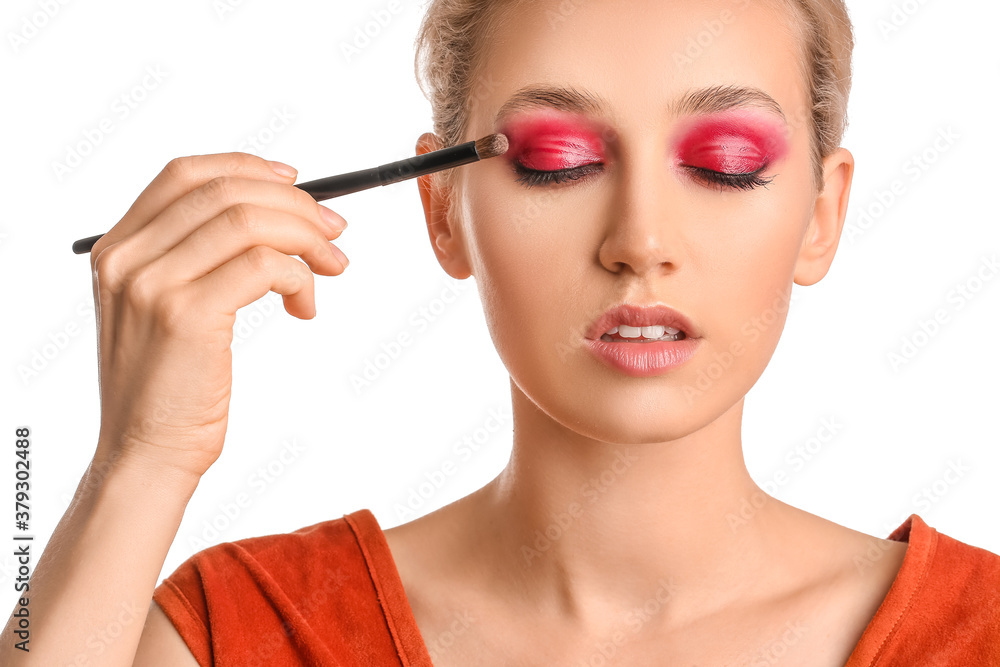 Poster Young woman applying beautiful eyeshadows against white background