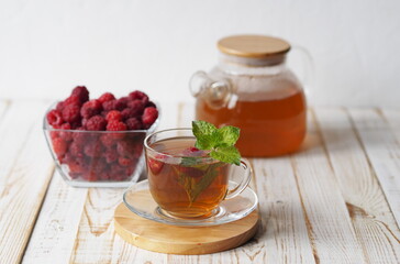 Autumn late raspberries. Herbal medicinal tea with raspberries on a light background.