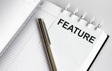 text FEATURE on the short note texture background with pen