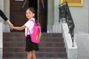 Mother walking her little daughter to school