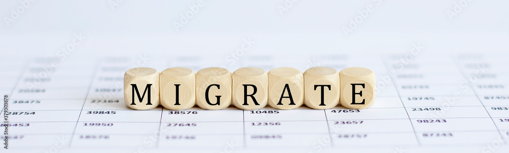 Aufkleber text migrate on a wooden cube blocks