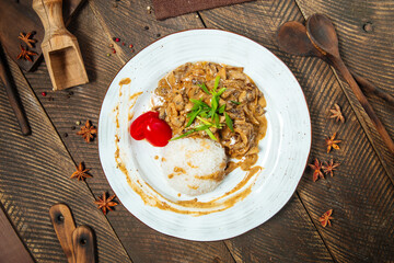On beef stroganoff with rice on a wooden table