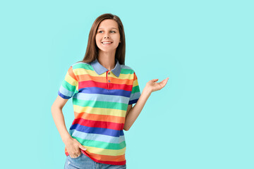 Young woman in rainbow clothes on color background. LGBT concept
