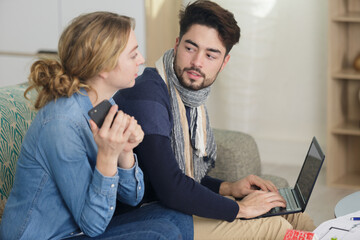 young married couple using laptop