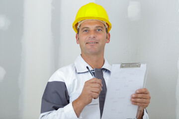 a builder writing on clipboard