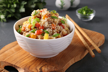 Fried rice with vegetables, garlic, ginger and green onion on dark background. Asian cuisine. Vegetarian food