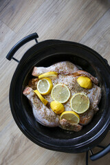 Chicken with lemon slow cooking in slow cooker.
