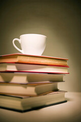 a cup on the pile of books