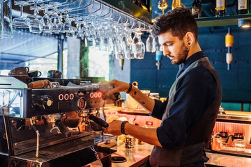 Professionally verified gestures, worked out to automatism. An experienced cafe worker making delicious coffee on an expensive coffee machine. Espresso, latte or cappuccino - obrazy, fototapety, plakaty