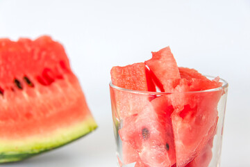 Red ripe watermelon, sliced on a white background. Watermelon slices in a glass.
