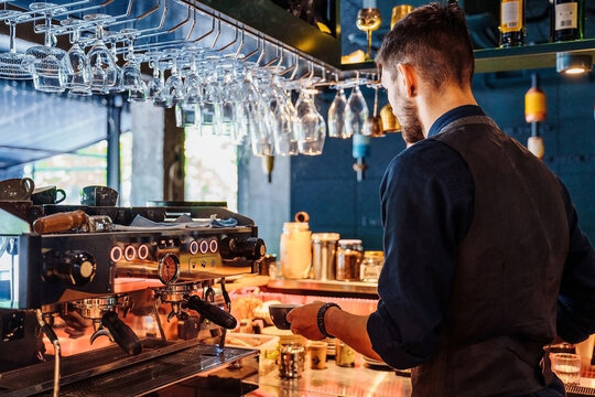 Professionally Verified Gestures, Worked Out To Automatism. An Experienced Cafe Worker Making Delicious Coffee On An Expensive Coffee Machine. Espresso, Latte Or Cappuccino