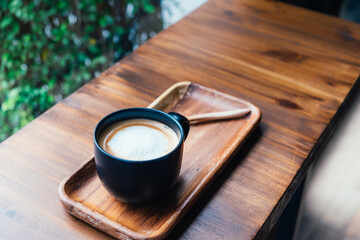 Cup of coffee on wooden table in cafe. Hot latte the best start to any morning.