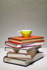 a cup on the pile of books