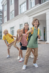 Schoolchildren playing in school yard and feeling happy