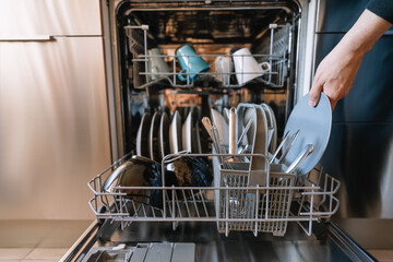 Man loading dishwasher in the kitchen