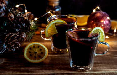 Christmas mulled wine with oranges and spices on wooden background.