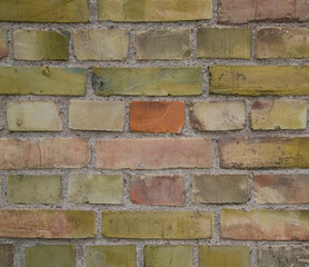 Horizontal detail shot of old brick wall for background. Colorful texture with red and green bricks