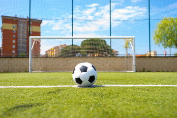 Vintage soccer ball on grassy field against net © 2Design