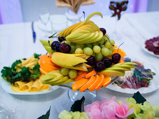 fruit plate with fresh grapes, cherries, orange, banana and Apple