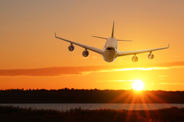 Modern airplane landing at sunset. Air transportation