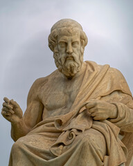 Fototapeta na wymiar Plato statue: the ancient Greek philosopher sitting in deep thoughts, Athens Greece