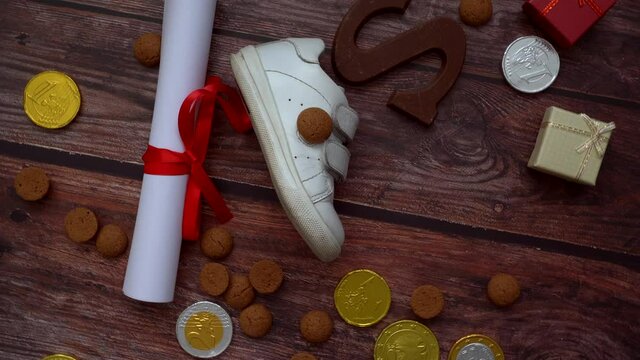 Dutch holiday Sinterklaas background. Rotation children shoe, carrots for Santa's horse, gifts, traditional sweets pepernoten and chocolate letter. Schoentje zetten concept. 4k video