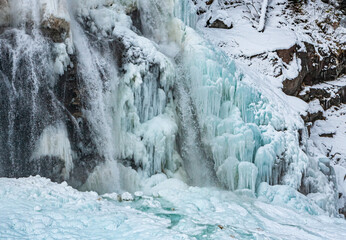 Fototapeta na wymiar Wasserfall im Winter: Wasser gefroren und flüssig