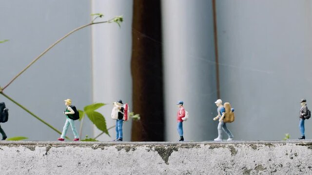 people walking in a row over an old fence