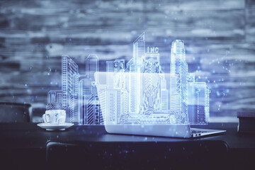 Desktop computer background in office and big town buildings hologram drawing. Double exposure. Smart city concept.