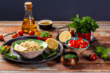 set of ingredients of the classic Tabbouleh recipe. Traditionally food Levantine vegetarian salad with parsley, mint, bulgur, tomato